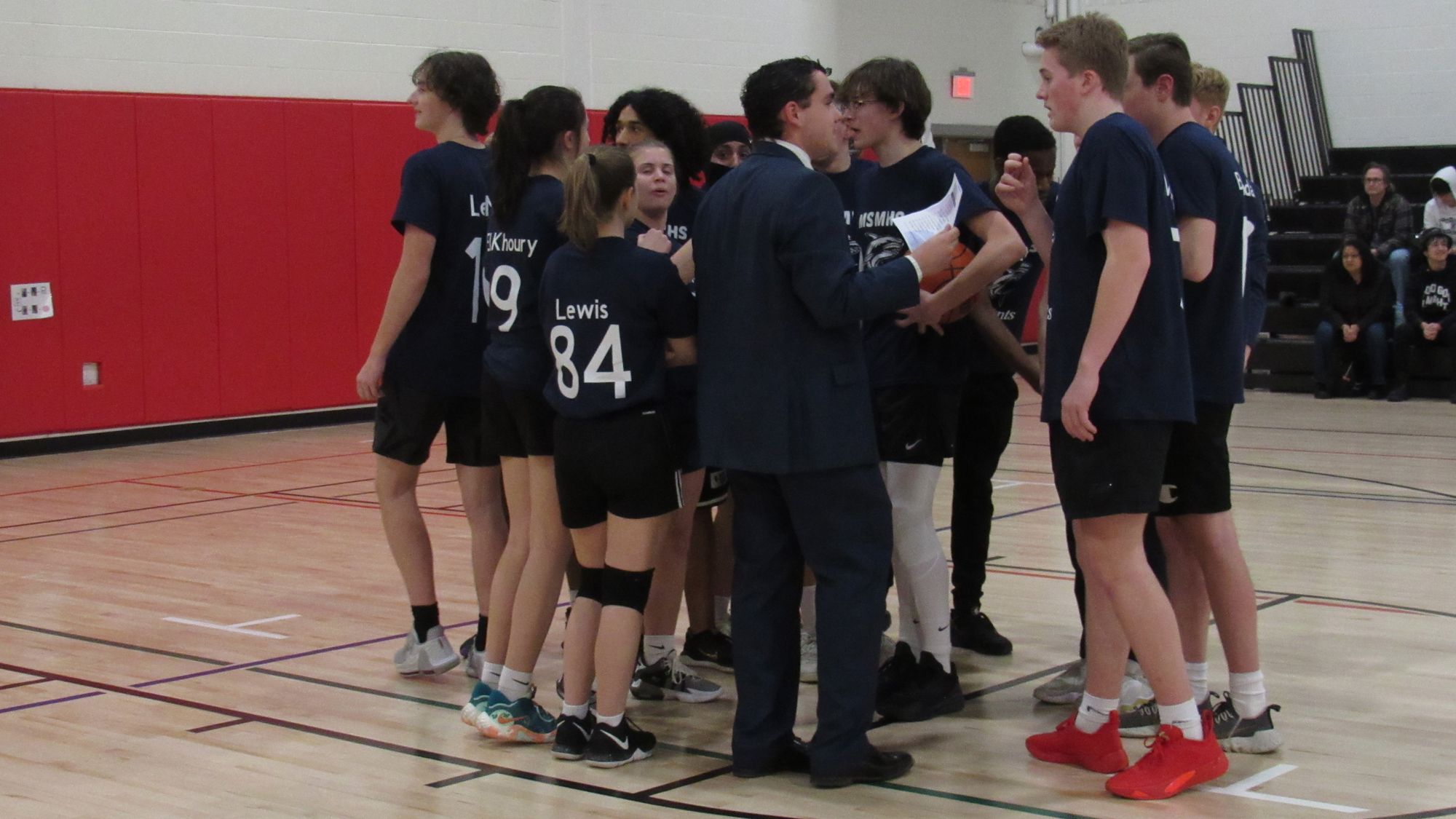 Students in blue uniforms huddle up.