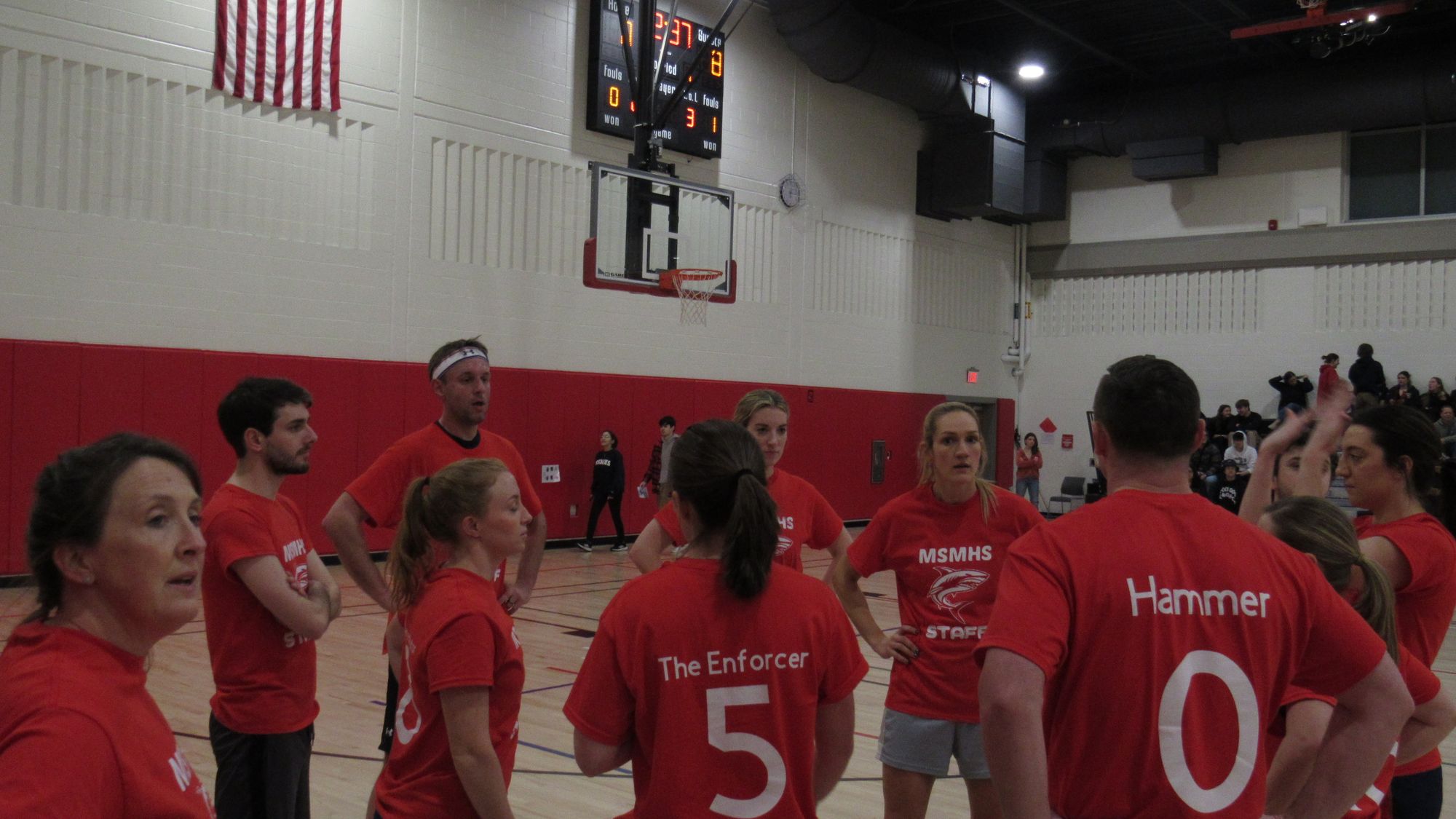 Teachers in red uniforms group together.