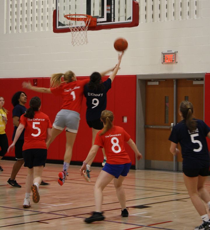 Student jumps to shoot on a basketball hoop.