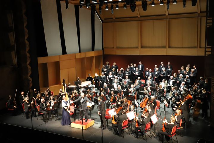 Choir and orchestra perform on stage.