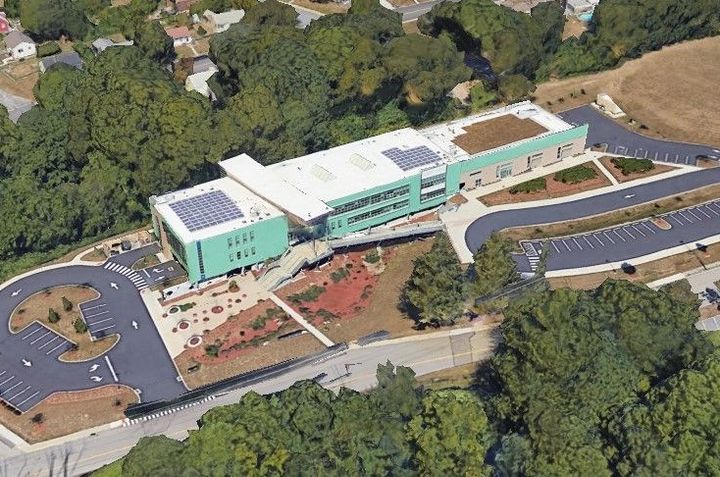 A satellite view of MSMHS shows the green roof on the right side of the image.