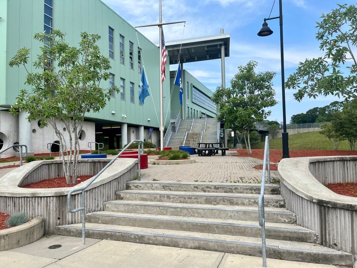 Concrete stairs lead up to a foam-green building.